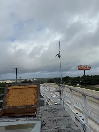 Rooftop of Automotive Specialists in Oak Hill with a MeshCore LoRa solar repeater on a 10' pole