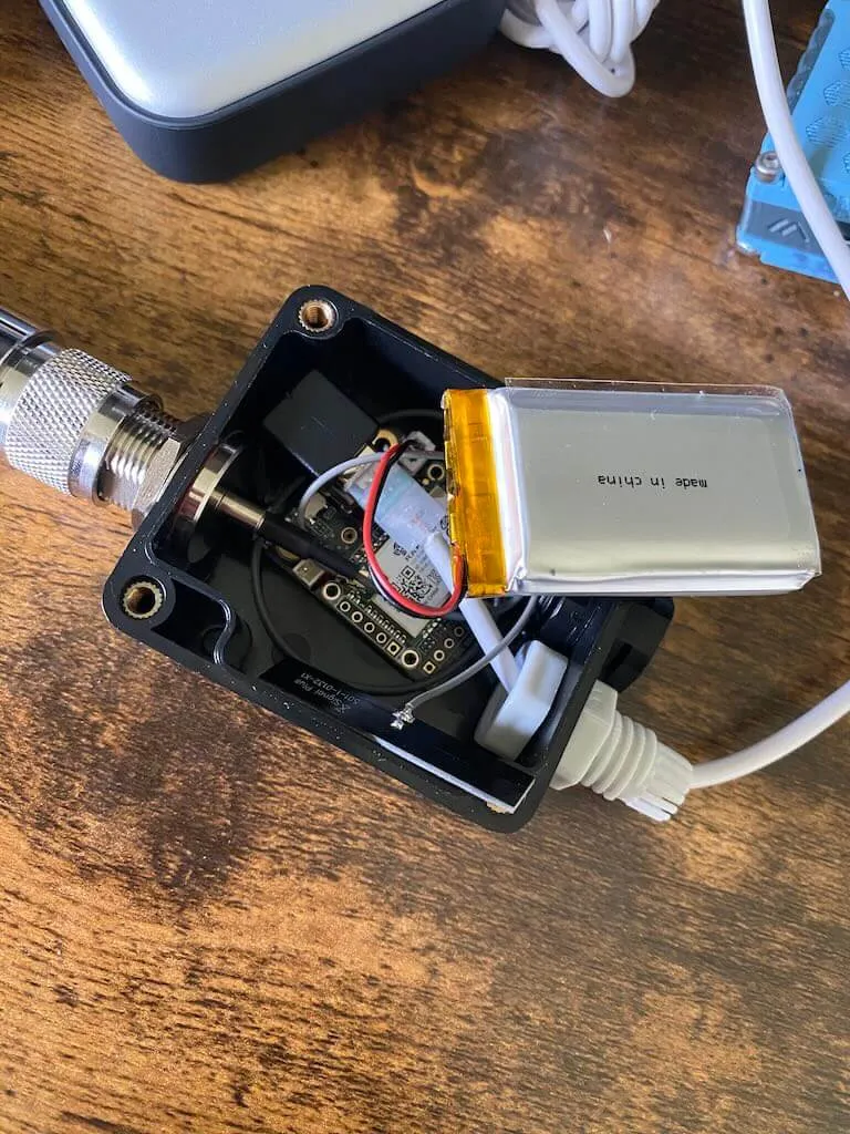 Inside view of the junction box showing the RAK 19003, battery, and short interconnects packed into the tiny enclosure