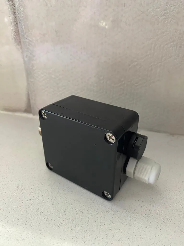 External view showing the USB-C solar panel passthrough and the drain plug vent on the side of the junction box